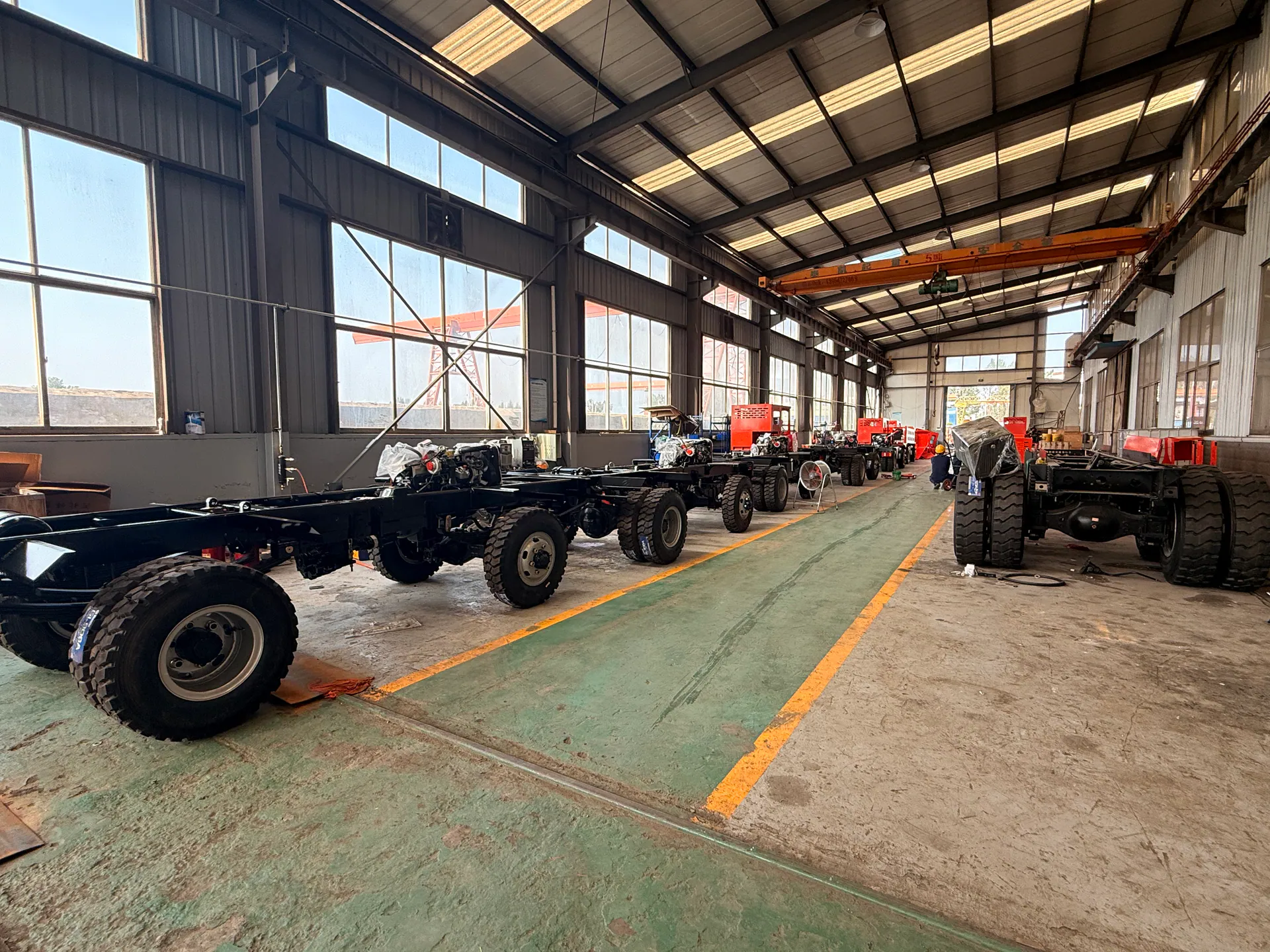 Mining truck chassis arranged on a workshop production floor.