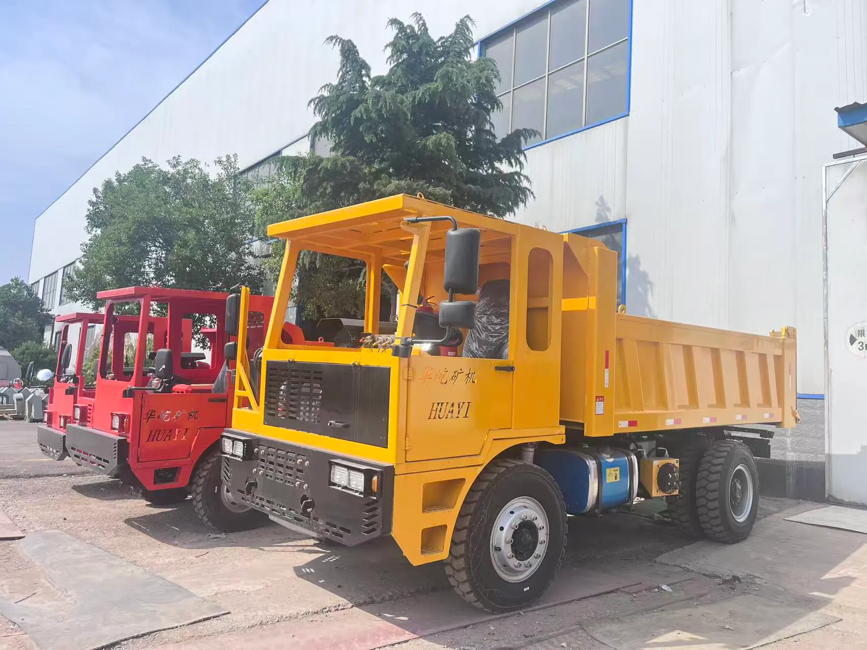 Red and yellow mining trucks arranged together outside.